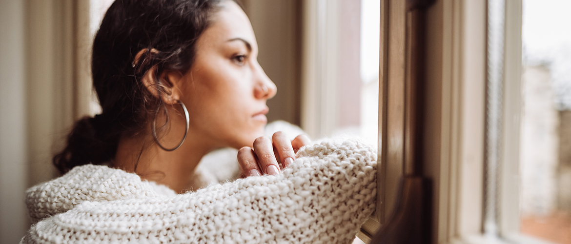 pensive woman looks out the window