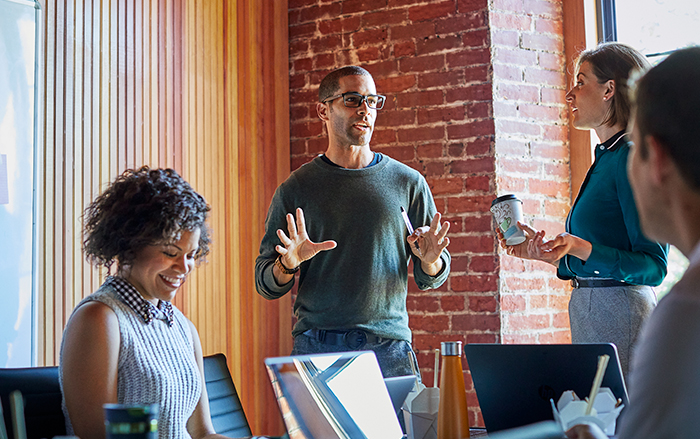  Group of diverse coworkers collaborate together in office space